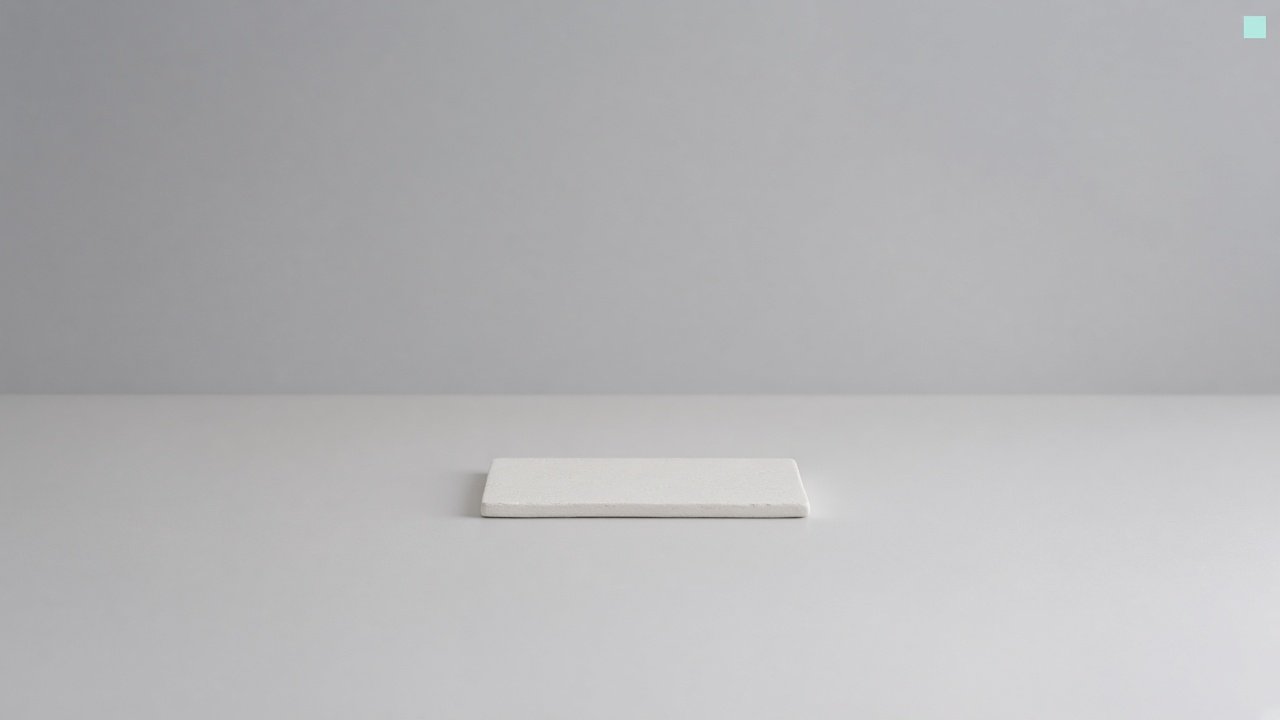 A single ceramic slab centred on a wide empty studio table
